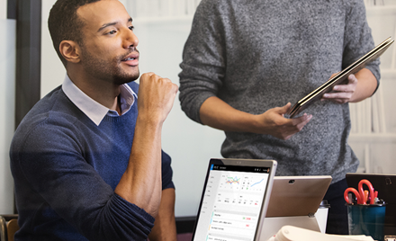 A man sits in front of his open laptop during a meeting.