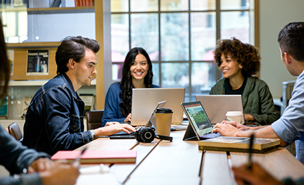 A group of workers collaborate around a table.