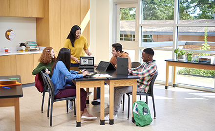 Image of five workers gathered around a table.