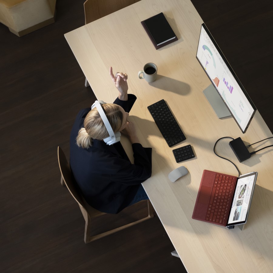 Overhead view of remote employee using multiple screens.