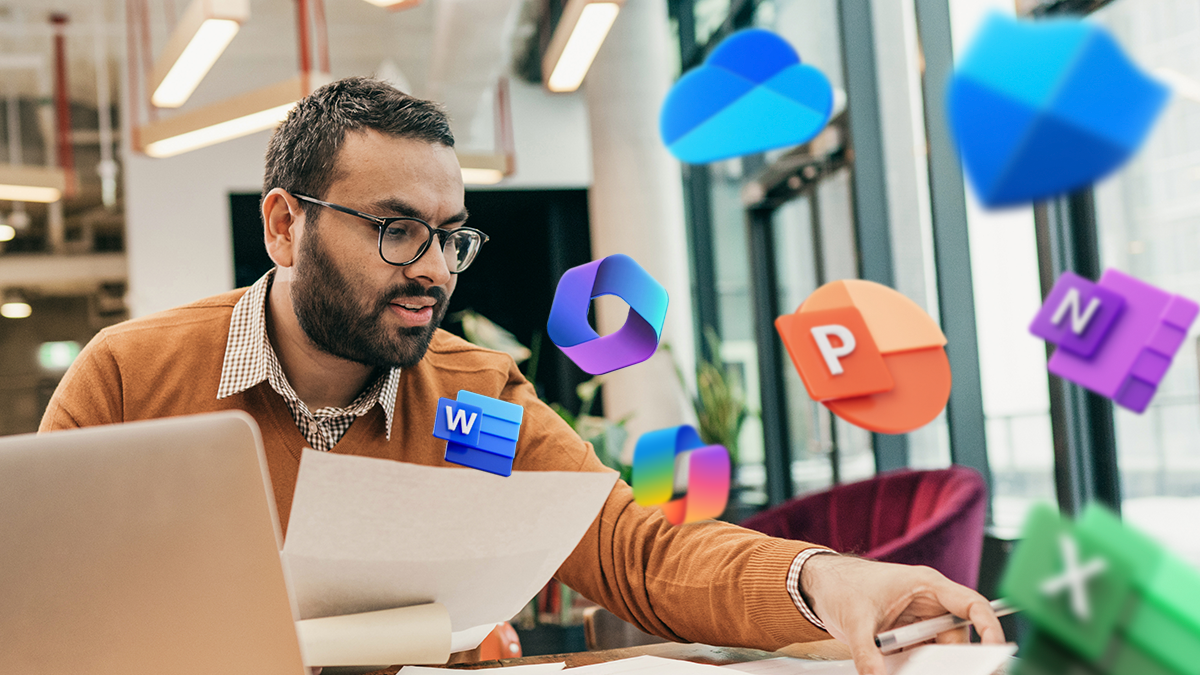 An financial advisor works at a table in a shared office space. On the right side, the image is overlaid with icons of multiple Microsoft 365 apps and the Copilot icon.