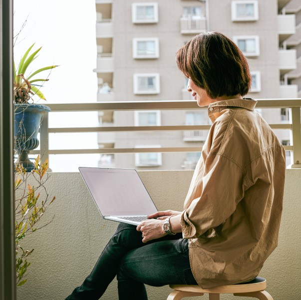 Woman teleworking on her balcony at home.